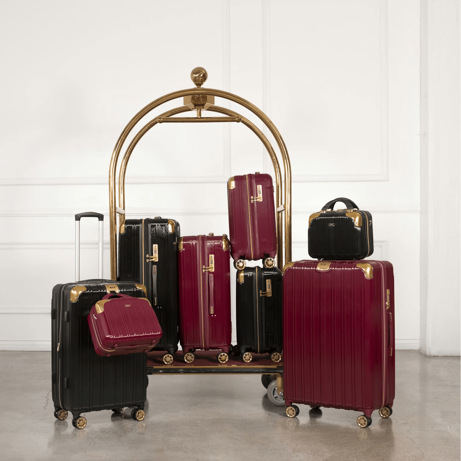 Collection of suitcases on a luggage rack against a white wall.
